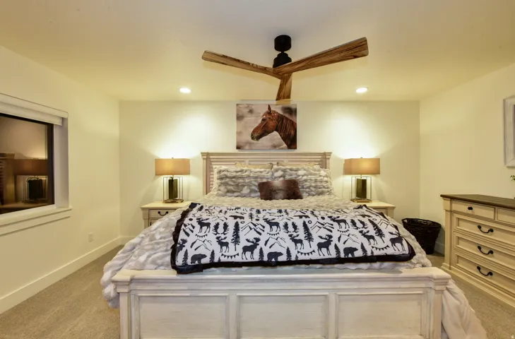 Recessed lighting, ceiling fan with wood-finish blades, window with roller shade, paneled wood-finish dresser, and carpeted flooring