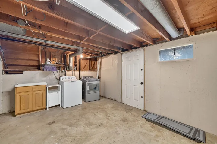 Basement space with exposed wood ceiling joists and concrete flooring