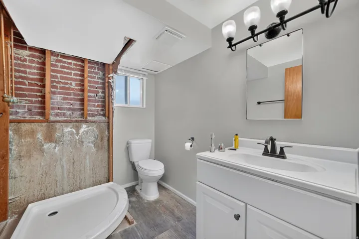 White vanity with integrated sink, matte black faucet, and rectangular mirror