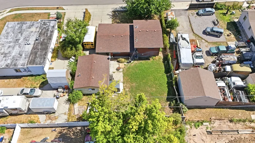 Two residential structures, detached garage, grassy lawn, and paved driveway areas
