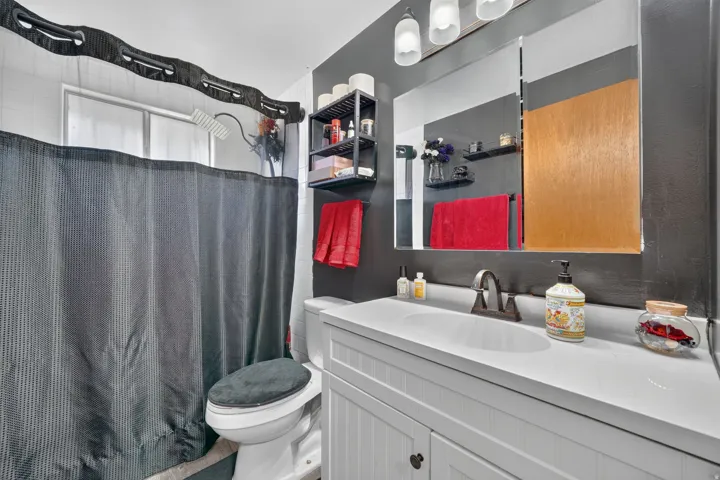 White vanity with integrated sink and dark bronze faucet