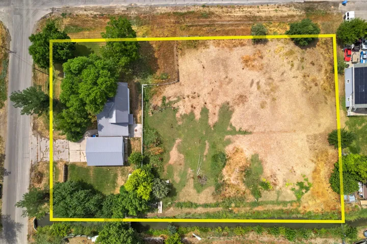 Spacious lot featuring a standalone structure with a metal roof and an extensive open land area