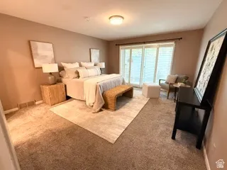 Sliding glass doors with internal blinds, flush-mount ceiling light fixture, neutral tone wall paint, and carpeted flooring