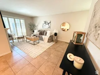 Tile flooring, neutral wall tones, large window with plantation shutters, built-in wall niche, and integrated shelving