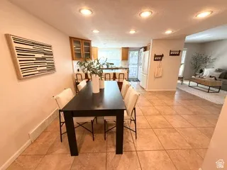 Recessed lighting, tile flooring, wood-finish cabinetry, and a full-size refrigerator