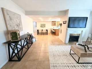 Ceramic tile flooring, white fireplace mantel, and integrated television mount