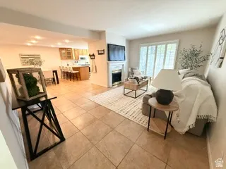 Tile flooring throughout, recessed lighting, and a fireplace with a white mantel