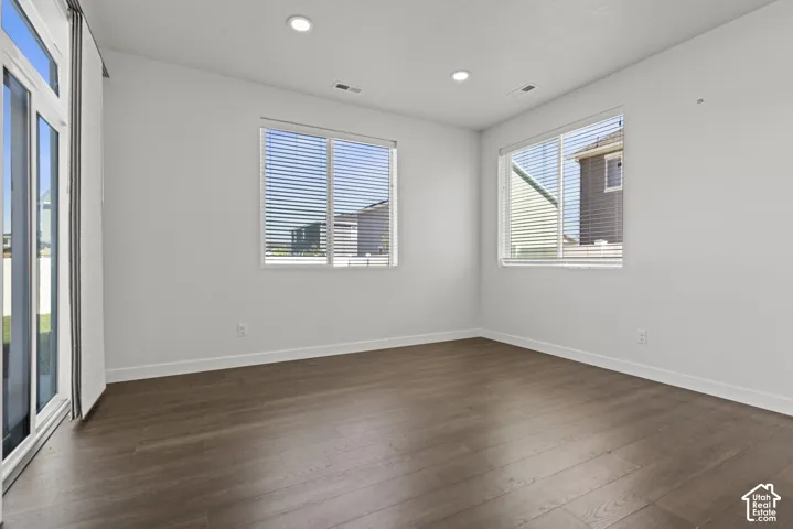 Wood-finish flooring, recessed ceiling lighting, and multiple windows with blinds