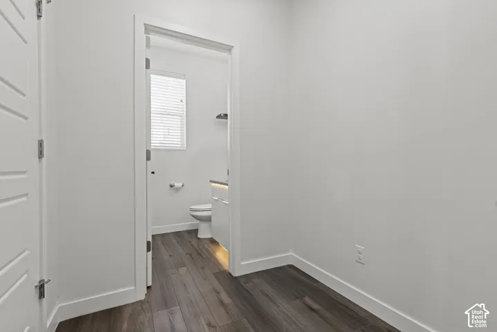 Wood-finish flooring throughout, white walls, and a recessed ceiling light