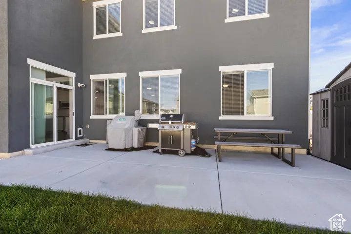 Concrete patio with a gray stucco exterior and white-framed windows