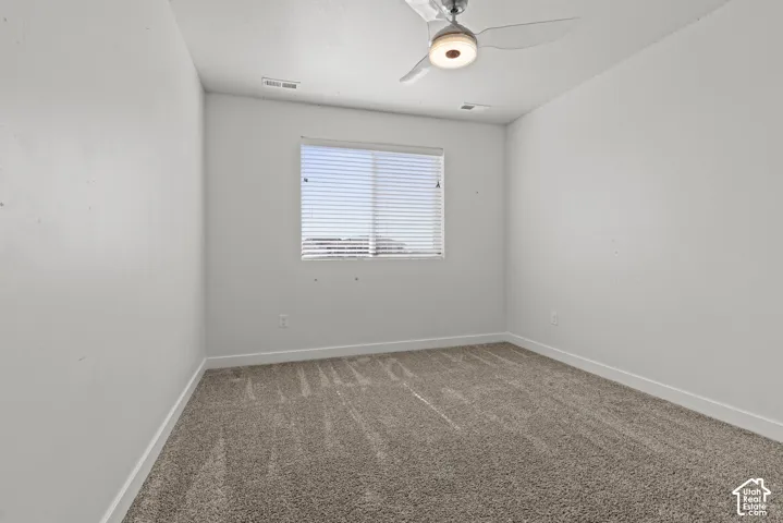 Light gray carpeting, white walls, and a window with horizontal blinds