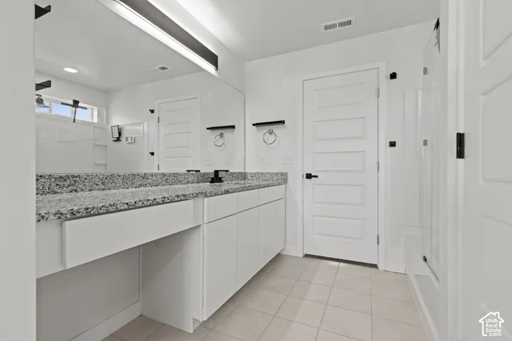 Double vanity with a speckled countertop, integrated sinks, and matte black fixtures