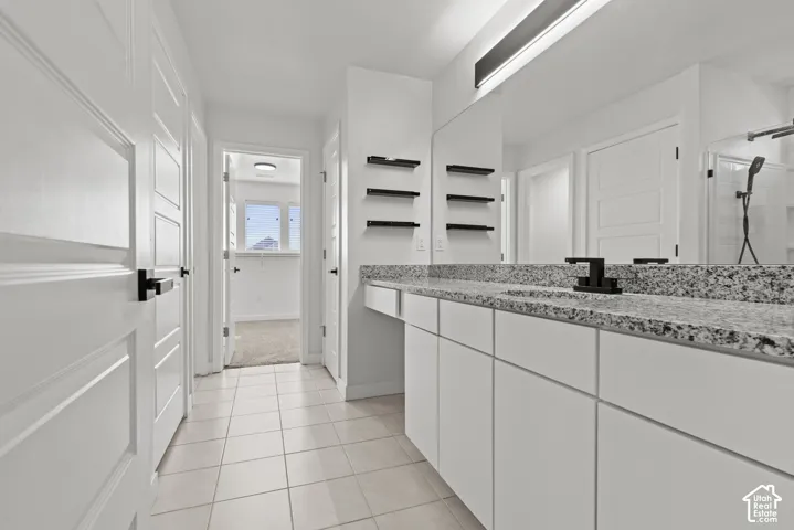 Double vanity with granite countertop, integrated sinks, and matte black fixtures