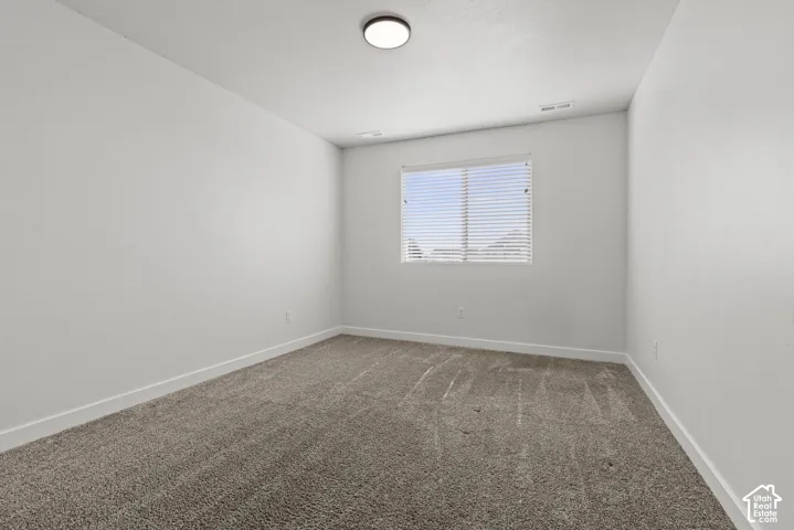 Neutral wall color with a window featuring horizontal blinds