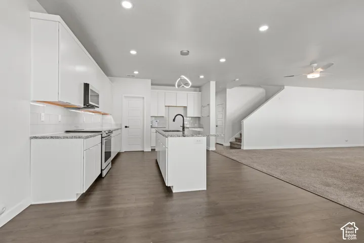 Modern kitchen featuring white cabinetry, light-toned countertops, and a white subway tile backsplash