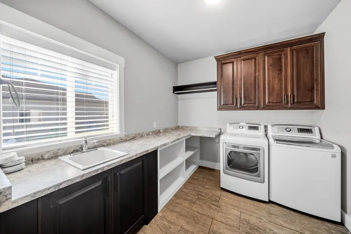 Integrated laundry room featuring a large window, extensive countertop space and utility sink.