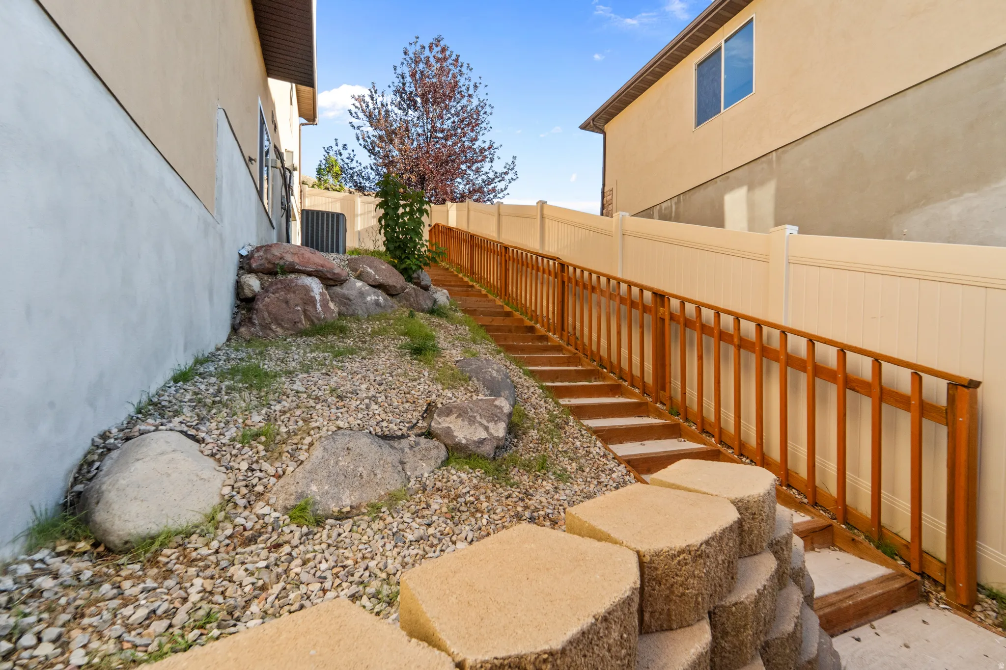 Tiered retaining wall with concrete block steps and wood railing