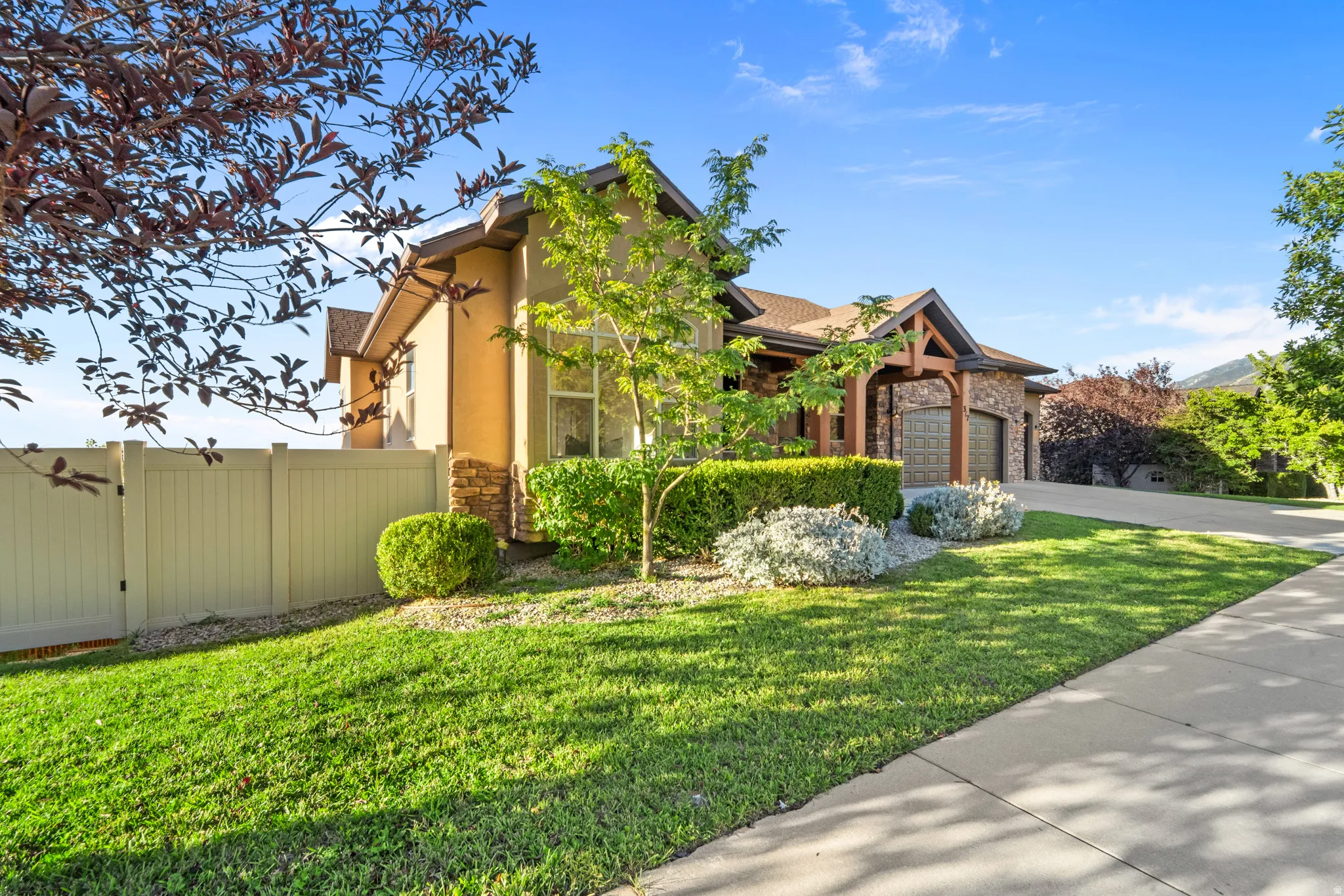 Stone and stucco exterior with a prominent arched wood beam entrance