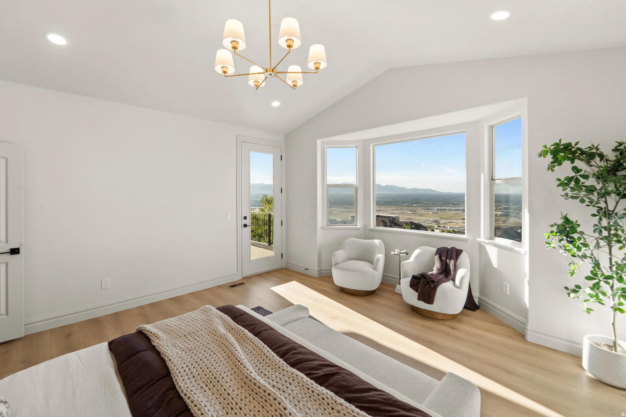 Vaulted ceiling with a modern chandelier, wood-finish flooring, bay window, recessed lighting, and a glass-paneled exterior door