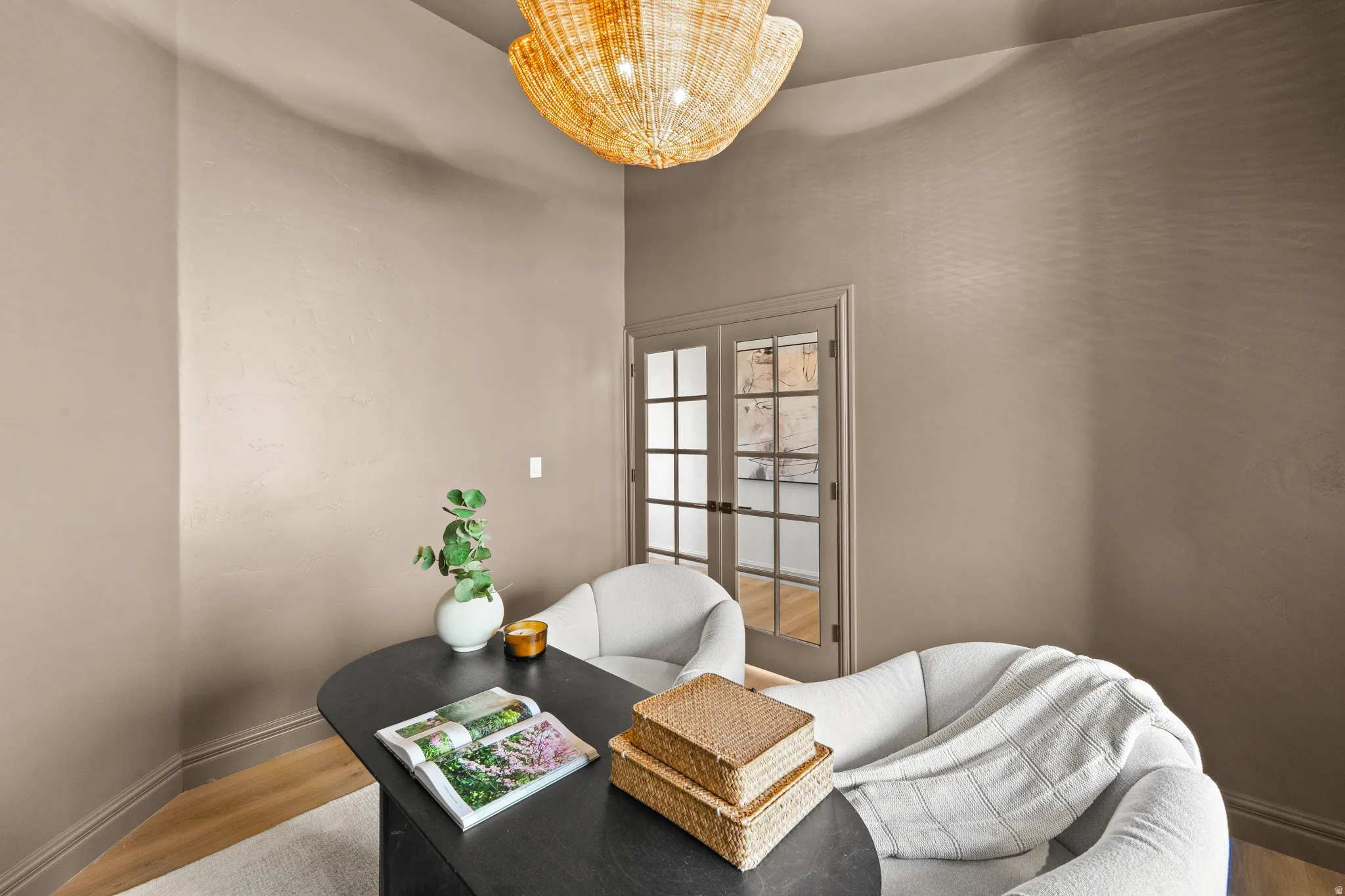 High ceilings, light wood-finish flooring, and a decorative ceiling fixture