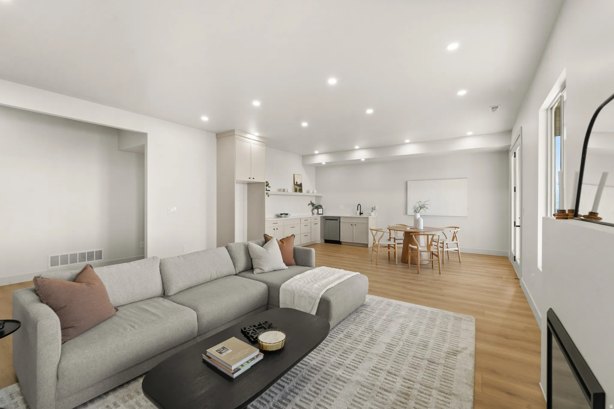 Recessed lighting, wood-finish flooring, and white walls
