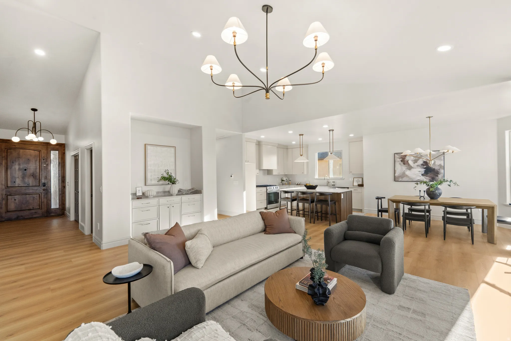 Hardwood-finish flooring throughout, integrated kitchen and dining areas, built-in cabinetry, modern pendant lighting, and a substantial front door