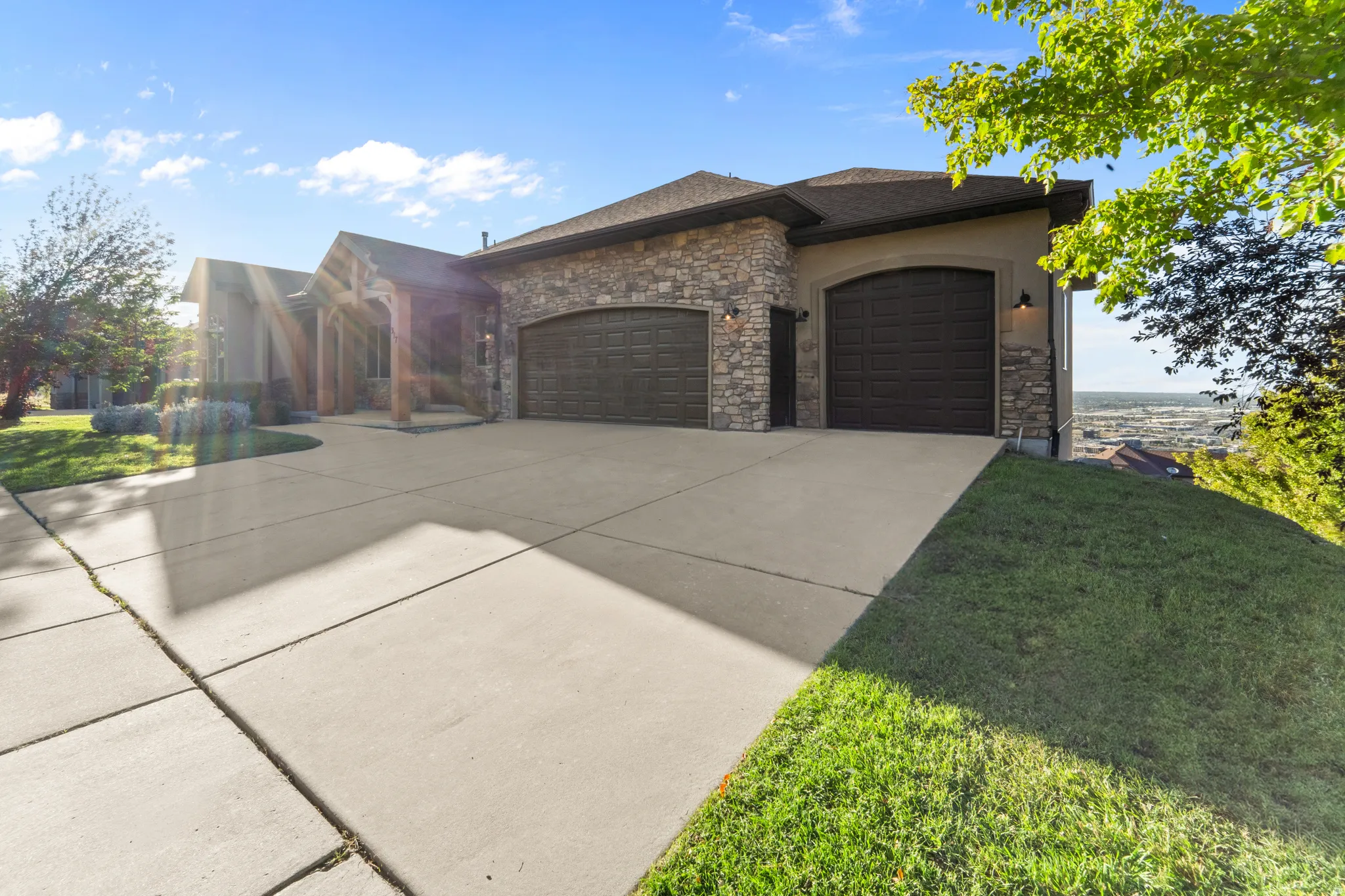 Stone veneer facade with stucco accents and a concrete driveway