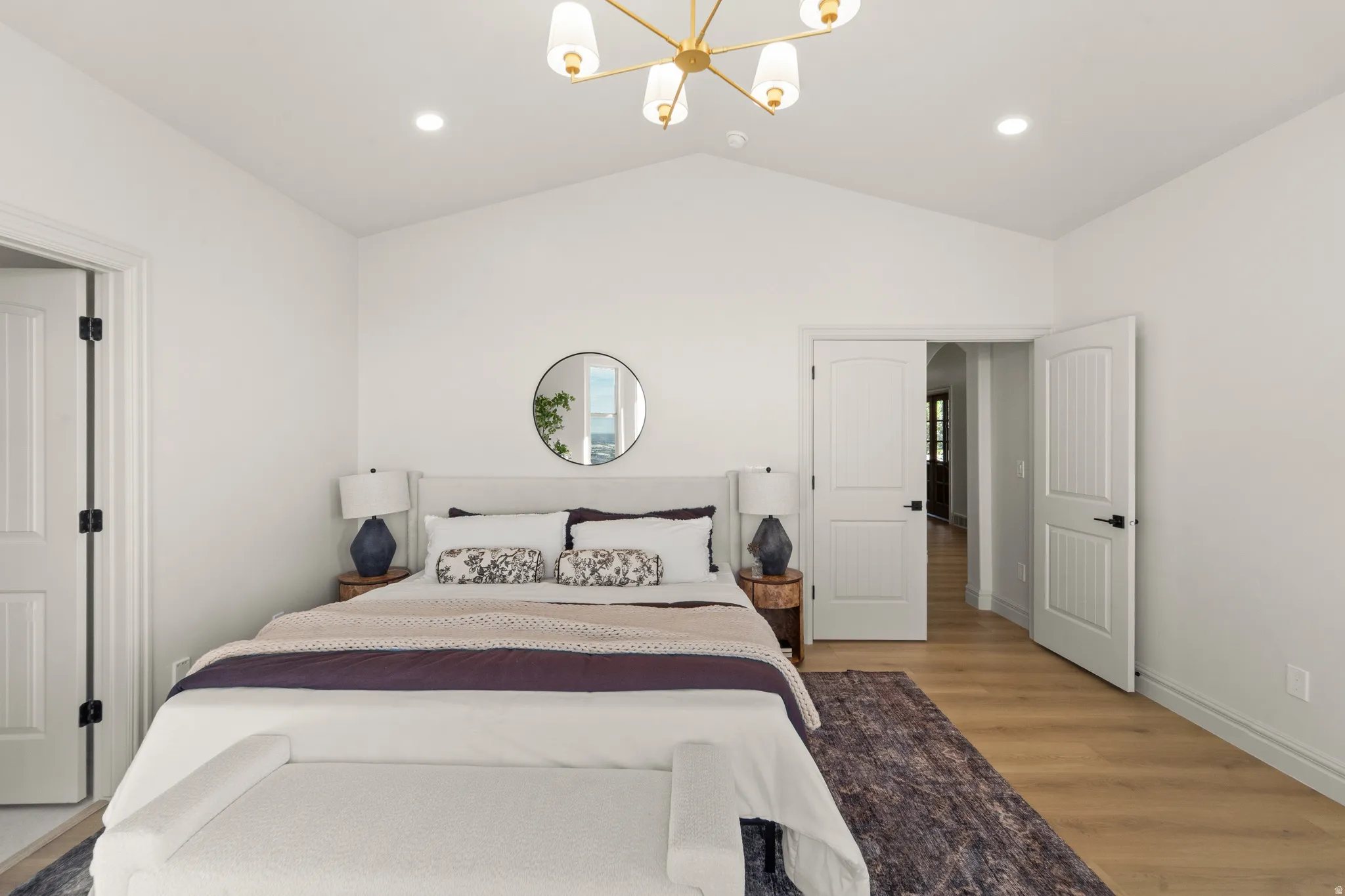Vaulted ceiling with a contemporary chandelier, recessed lighting, and wood-finish flooring