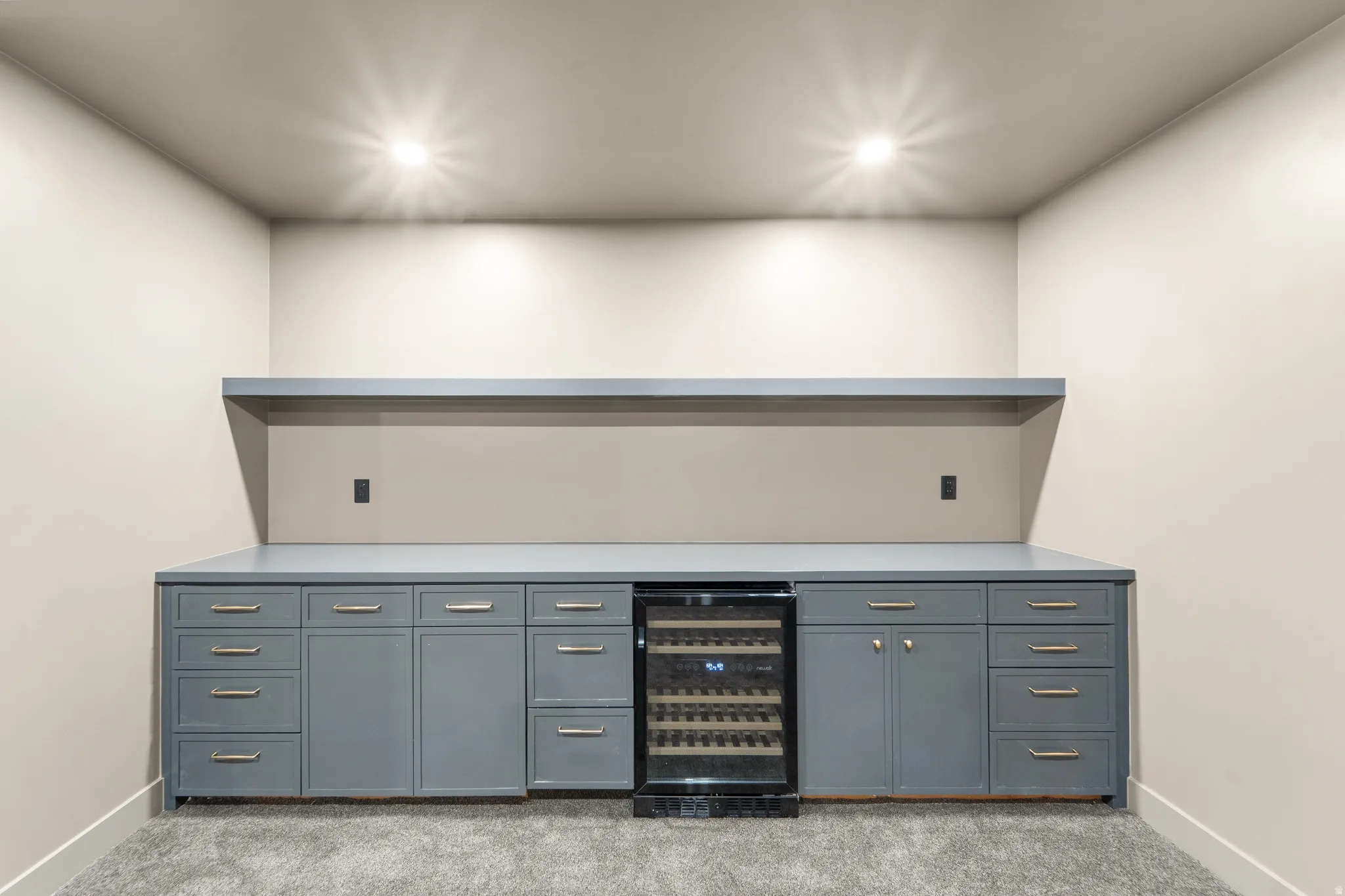 Built-in cabinetry with gray finishes, a wine refrigerator, and a coordinating floating shelf