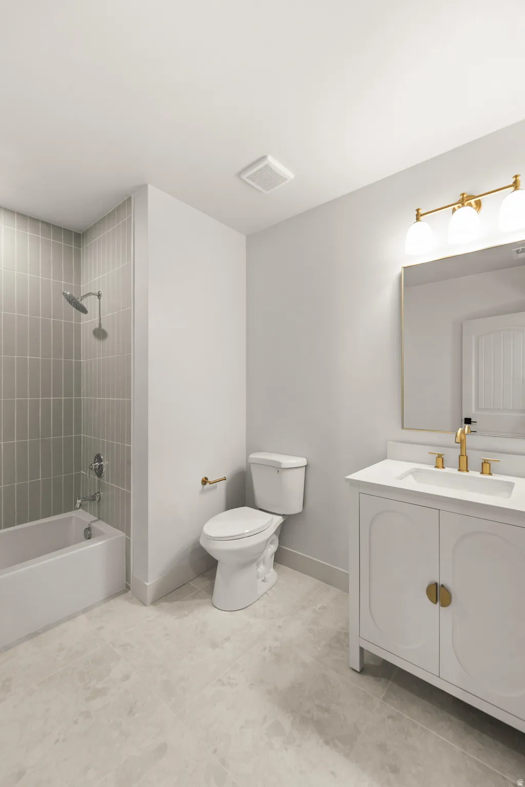 White vanity with gold-tone hardware, rectangular sink, and gold-tone faucet