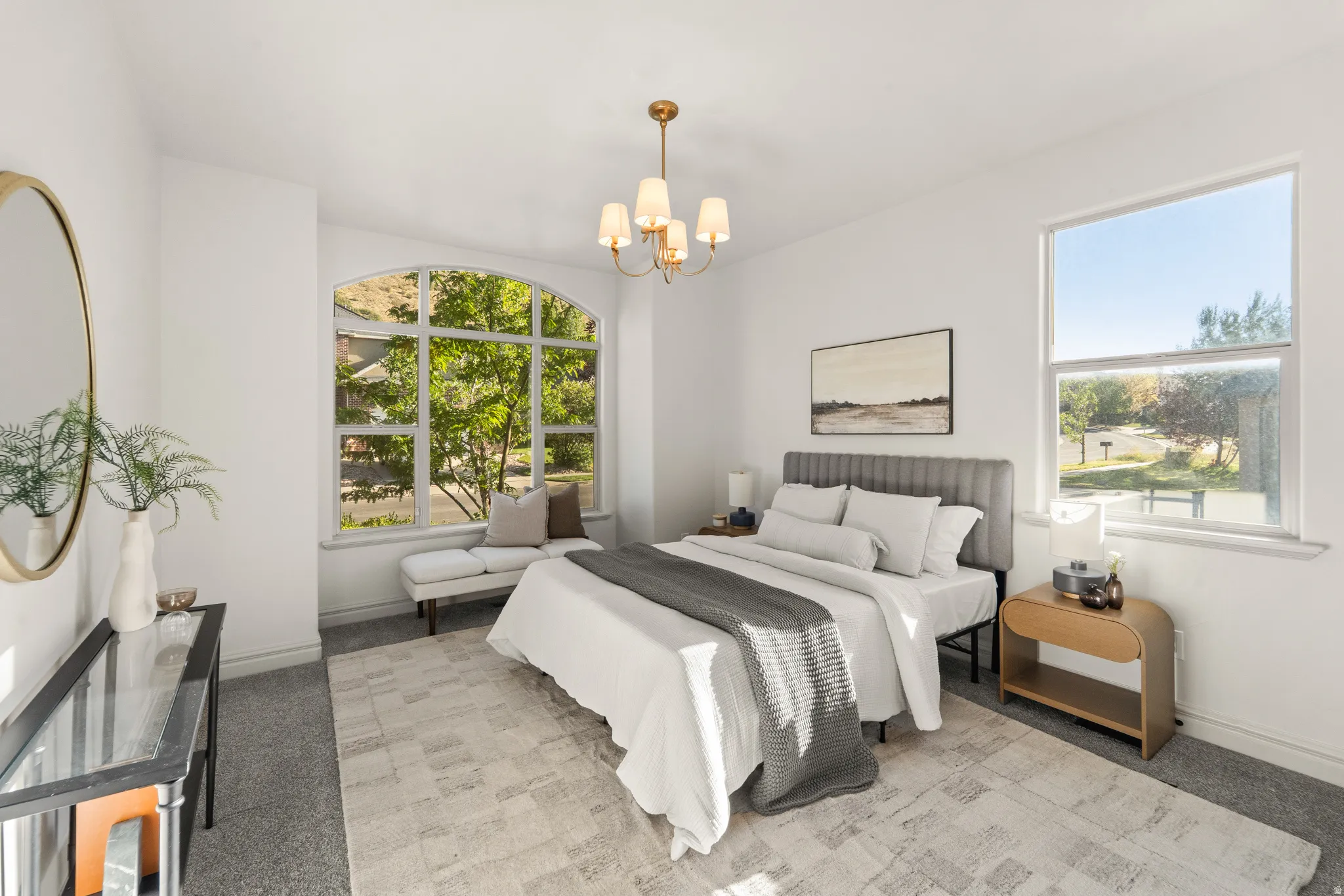 Arched window, high ceilings, large window, chandelier, carpeted flooring