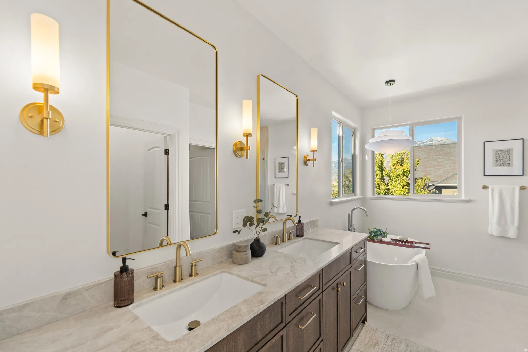 Dual vanity with gold-finish mirrors and sconce lighting