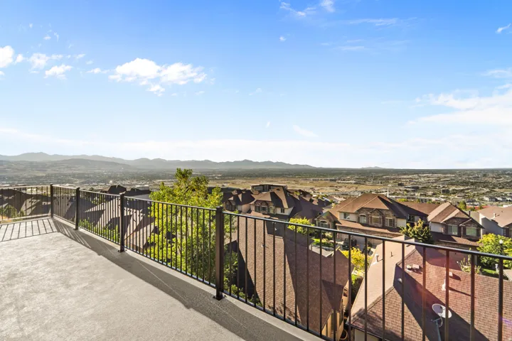 Expansive outdoor terrace featuring metal railings and a distant mountain backdrop