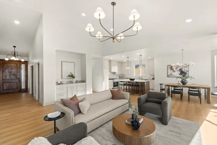 Hardwood-finish flooring throughout, integrated kitchen and dining areas, built-in cabinetry, modern pendant lighting, and a substantial front door