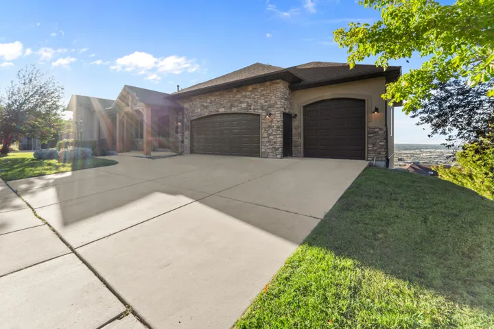 Stone veneer facade with stucco accents and a concrete driveway