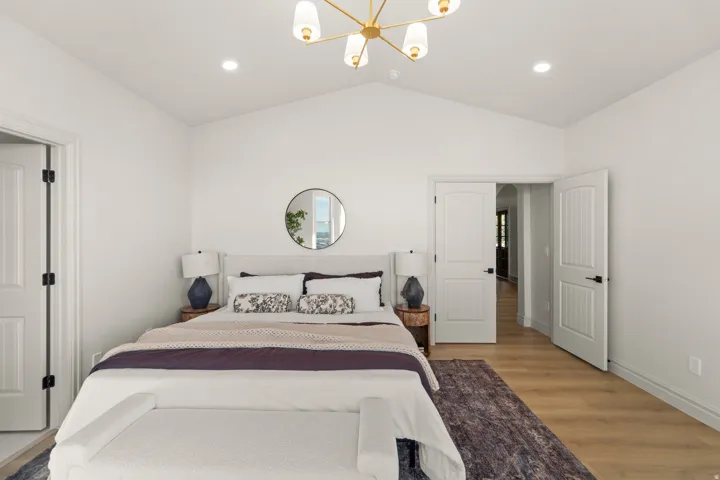 Vaulted ceiling with a contemporary chandelier, recessed lighting, and wood-finish flooring