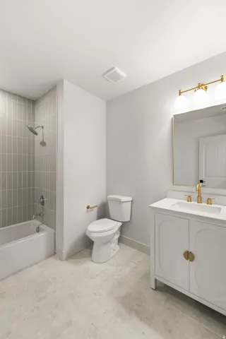 White vanity with gold-tone hardware, rectangular sink, and gold-tone faucet