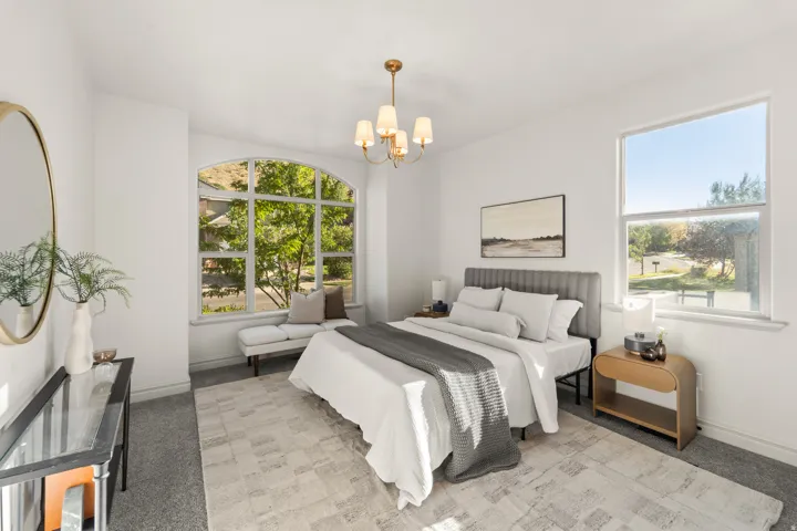 Arched window, high ceilings, large window, chandelier, carpeted flooring