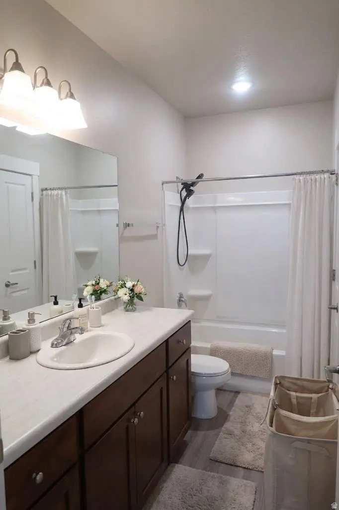 Vanity with wood-finish cabinetry, integrated sink, and ample countertop space
