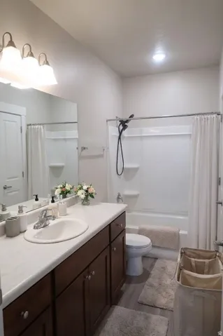 Vanity with wood-finish cabinetry, integrated sink, and ample countertop space