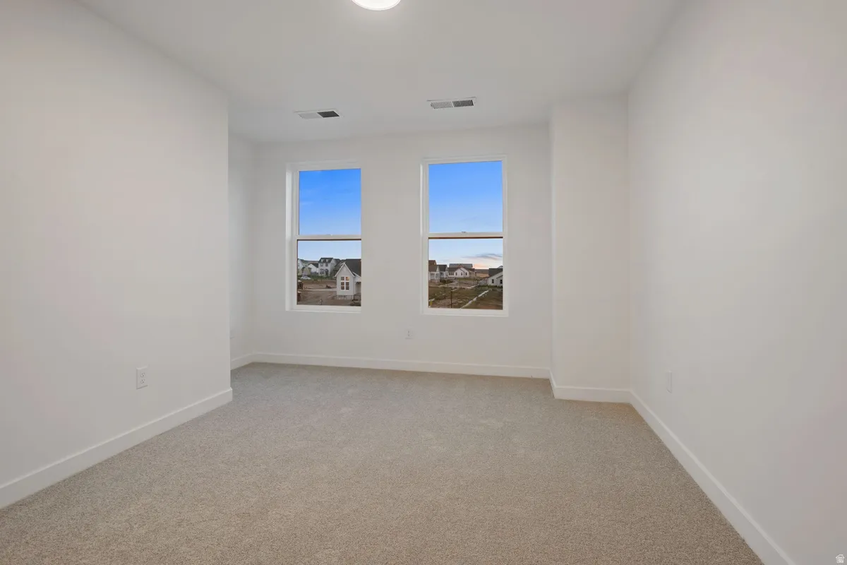 Neutral color palette, twin windows, recessed lighting, and light-toned carpeting