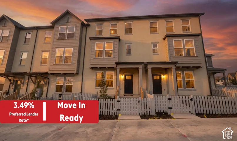Multi-level townhome architecture featuring a neutral stucco and siding exterior, private fenced front patios, covered entryways, and ample windows