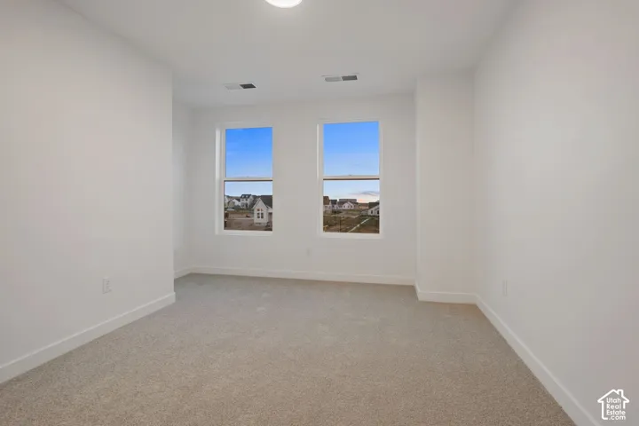 Neutral color palette, twin windows, recessed lighting, and light-toned carpeting