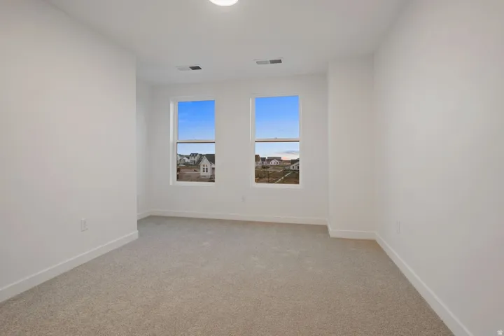 Neutral color palette, twin windows, recessed lighting, and light-toned carpeting