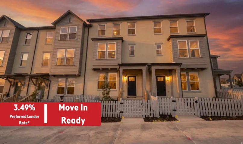 Multi-level townhome architecture featuring a neutral stucco and siding exterior, private fenced front patios, covered entryways, and ample windows