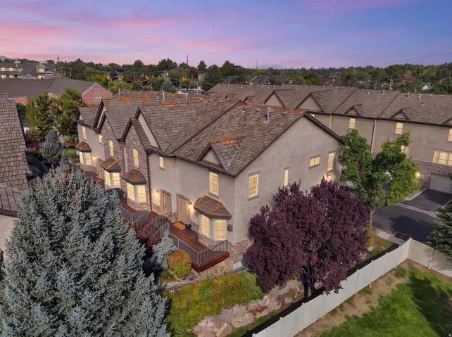 Townhouse exterior featuring stone accents, bay windows, and a multi-level deck