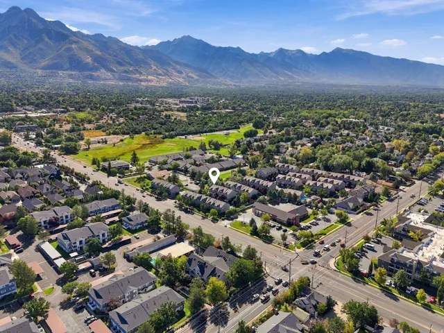 Expansive mountain scenery framing a developed residential area with varied architecture and mature trees
