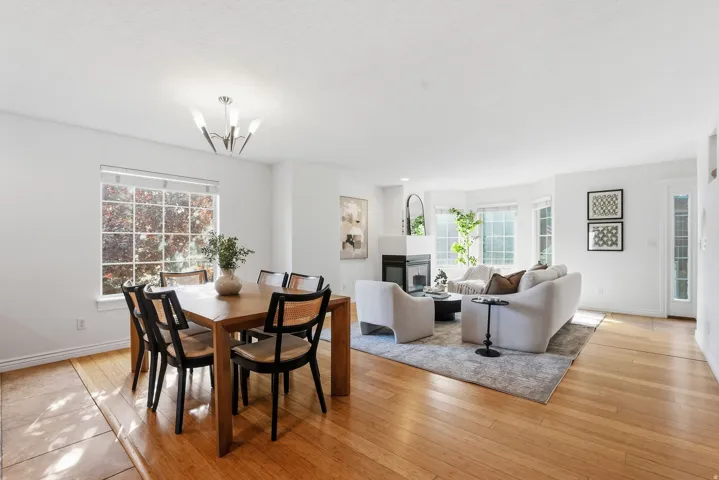 Hardwood flooring, recessed lighting, white walls, and a fireplace with a white mantel