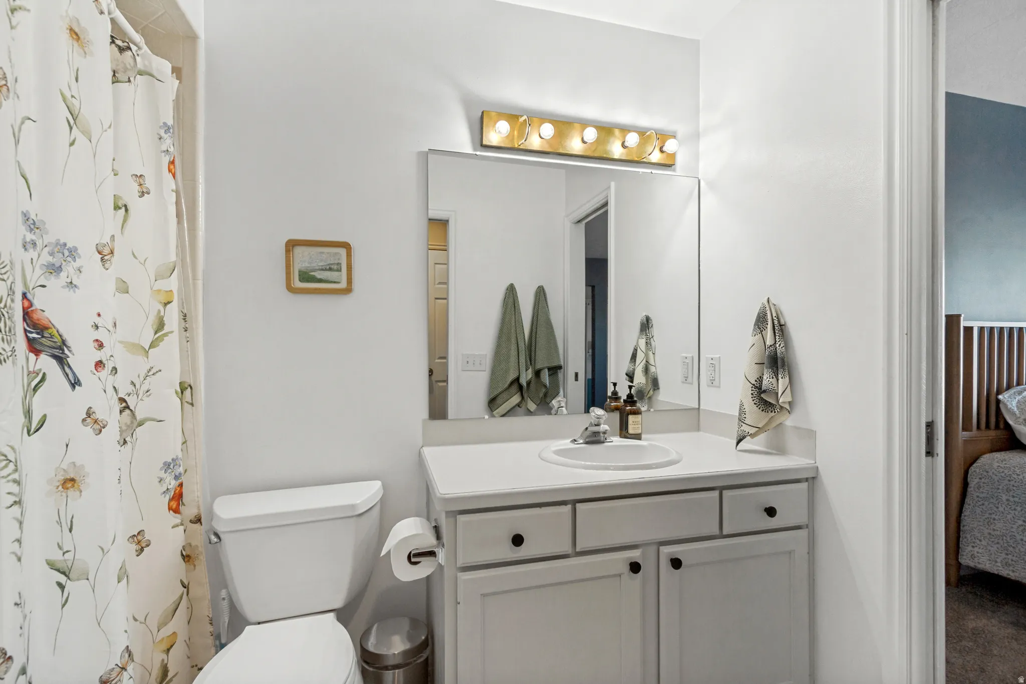 White vanity with cabinet storage, integrated sink, and white countertop