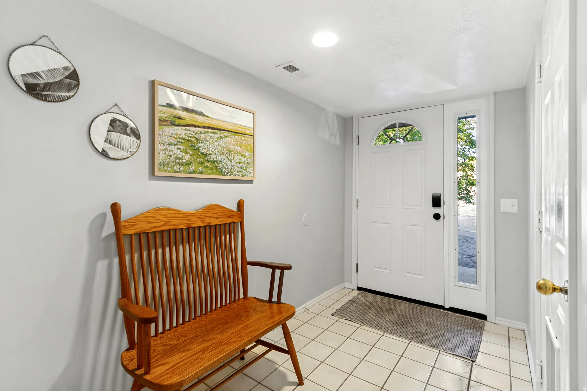 Entryway featuring a white door with an arched window, a tall sidelight, recessed lighting, and tile flooring